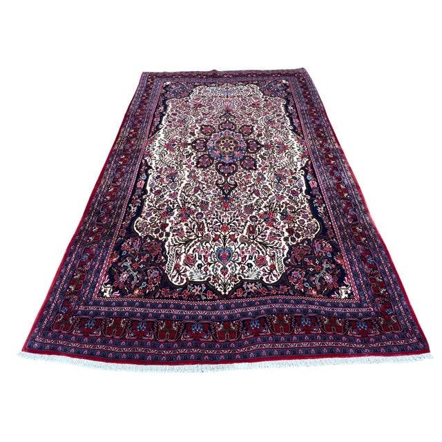 Vintage Persian Bijar rug, hand knotted in Iran from 100% wool. Measuring 7’3” x 11’3”, this rug features an elegant...