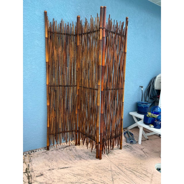 The Large bamboo canes tied together creating 3 panels. Between the Cane Frame are Bamboo rattan sticks wrapped together...