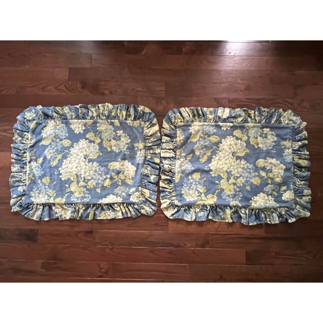 Pair of ruffled custom made shams in floral Waverly Rolling Meadows pattern featuring white and blue hydrangeas against a...