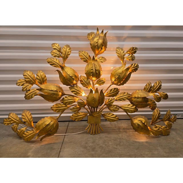 Beautiful Hollywood regency style wall sconce. These features 9 individual lights that illuminate the gold leafs. The...