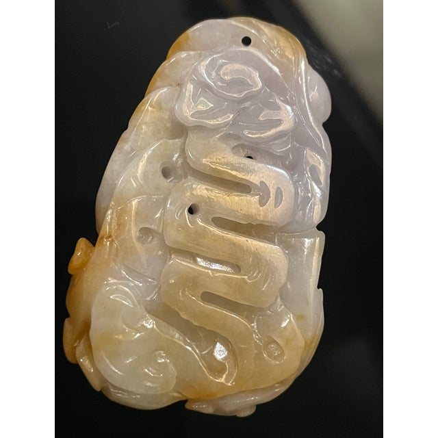This jade carving 61mm.x35mm. showcases two phoenix birds rendered in a traditional Chinese style, utilizing the natural...