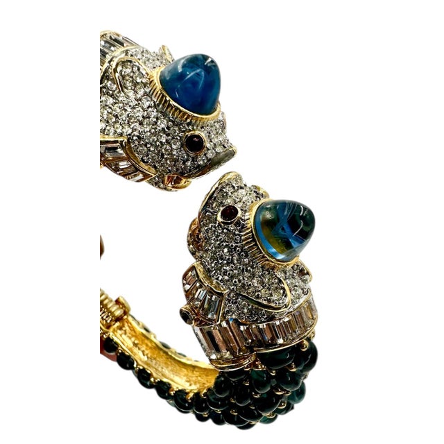 This hinged cuff bracelet with dragon heads at the open ends is by Kenneth Lane opens and one size for a comfortable and...