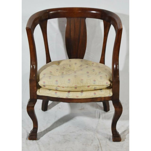 Chair has curved barrel back rail with shaped splats with inward swept arms with padded seat cushion resting on curved...