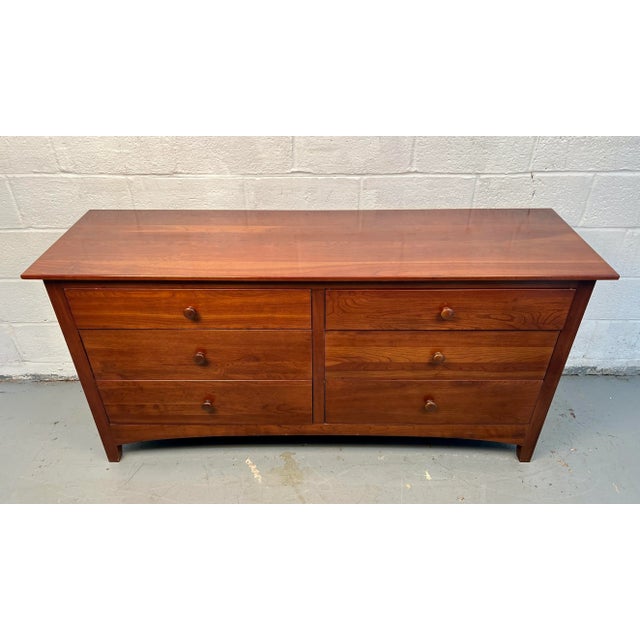 Classic mid-century modern cherry dresser by Ethan Allen, showcasing the brand’s signature craftsmanship. Features warm...