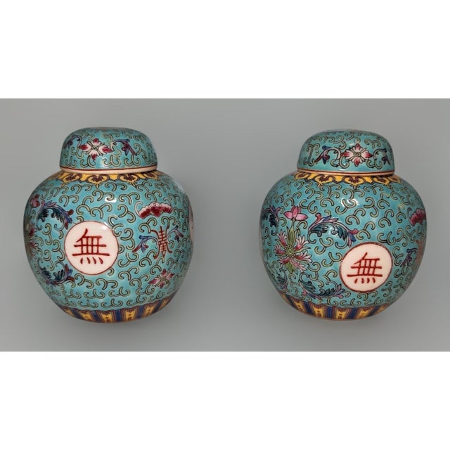A vibrant and pristine pair of vintage mid-century Chinese porcelain ginger jars featuring the iconic Wan Shou Wu Jiang...