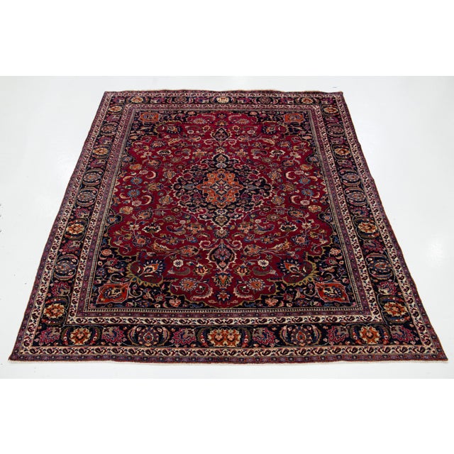 This is a beautiful vintage Kashan hand-knotted wool rug with a burgundy red field. It has multicolor accents and an all-...