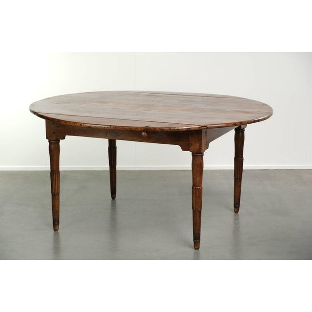This beautiful, rare oval/round antique French farmhouse table dates from the early 19th century and is made of walnut....