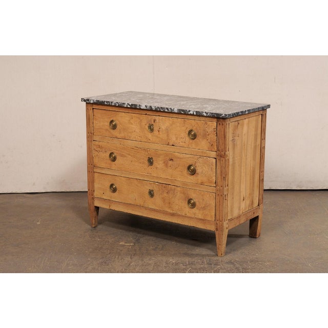 A French Louis XVI style chest, with its original marble top, from the 19th century. This antique commode from France,...