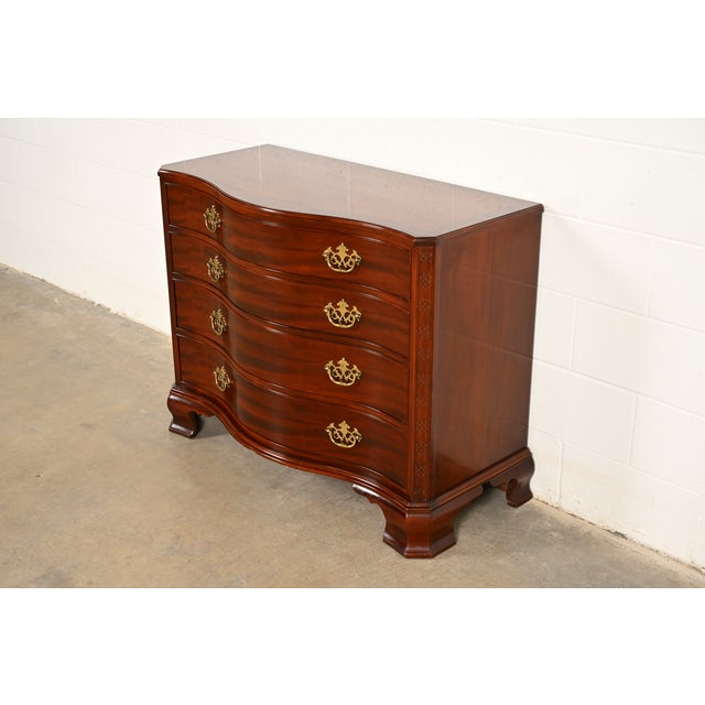 An exceptional Georgian or Chippendale style serpentine front dresser or chest of drawers By Baker Furniture, "Historic...