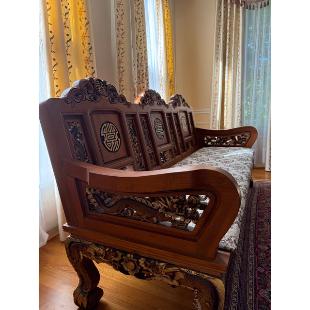 An exceptional hand-carved solid teak wood sofa imported from Thailand in 2001. This striking three-seat piece features...