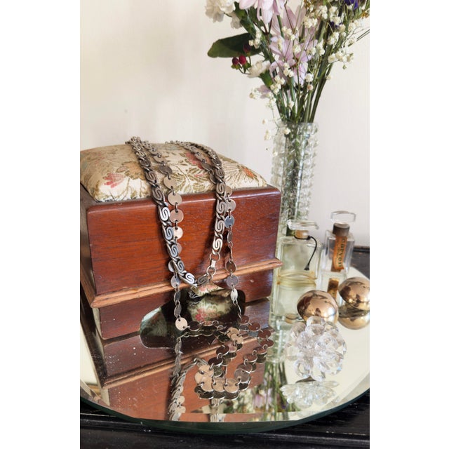 Vintage footstool, likely early 20th century or late Victorian era, with a solid wood base and floral-upholstered cushion....