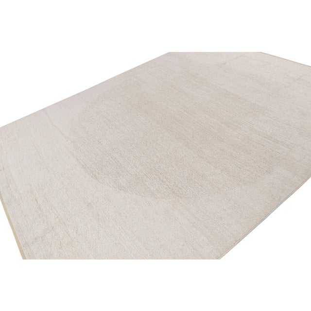 Hand knotted in wool, this 9x12 contemporary rug “Harmony” features a subtle single circle geometric pattern. On the...