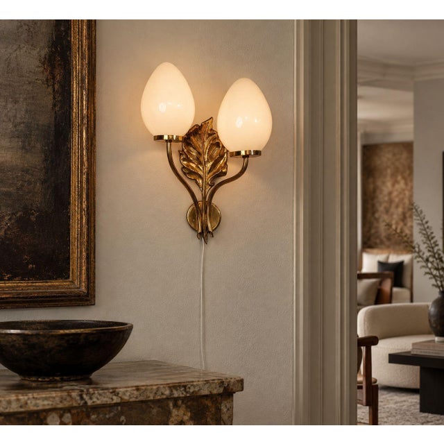 Swedish Mid-Century Modern, Double Wall Light or Sconce, Brass, Opaline Glass, Sweden, 1950s A decorative wall lamp...