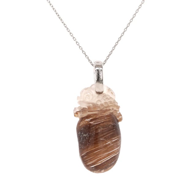 This pendant blends natural mystique with refined craftsmanship, centred around a striking 21.15ct rutilated quartz. Its...