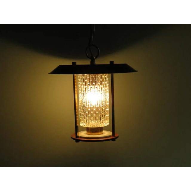 This round french lantern consists of a teak wooden plateau, a glass chalice with a graphic motif an a black metal plate...