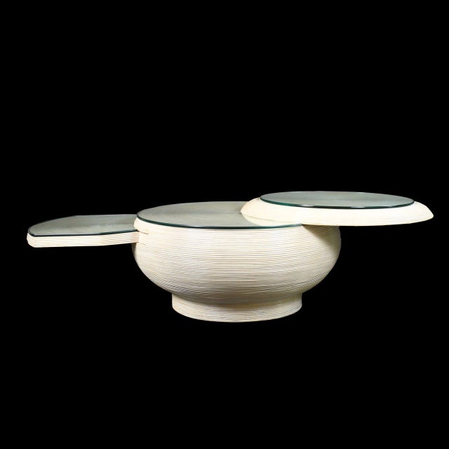 A large blonde pencil reed coffee table with a swivel top — a rare, playful mechanism wrapped in fine honey-toned reeds....