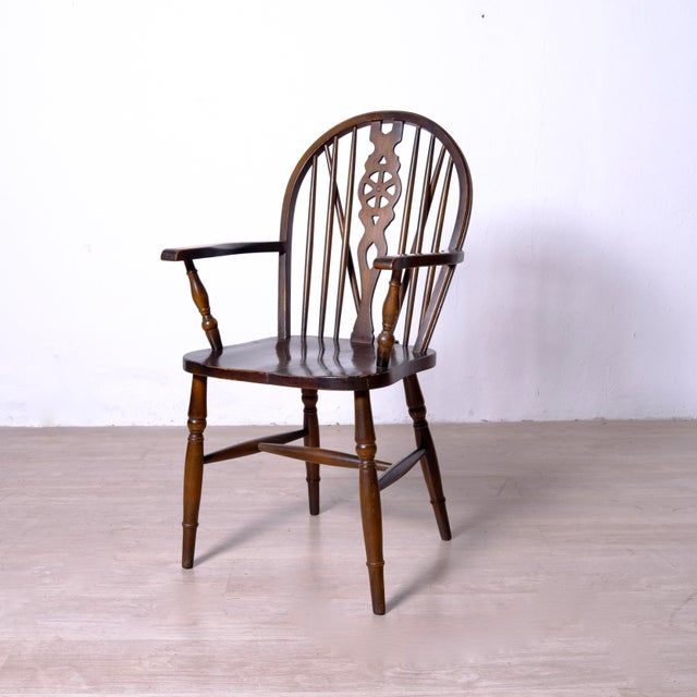 Description: Antique 19th-century English Windsor chair in wood, with a wheel-shaped backrest and armrests. Dimensions:...