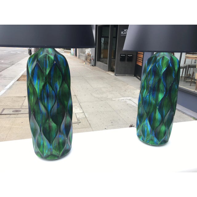 An incredible pair of tall mid-century modern ceramic table lamps, featuring a brilliant iridescent glaze in deep blue and...