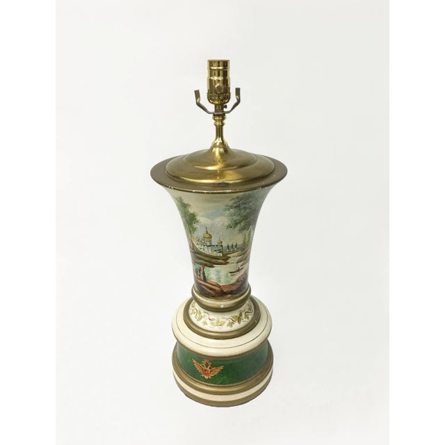 Vase shaped lamp with painted depiction of eastern european palaces on a river's edge. With a double headed eagle emblem...