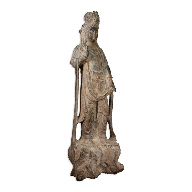 This serene stone sculpture depicts the Bodhisattva Guanyin, the goddess of mercy and compassion in Chinese Buddhism....