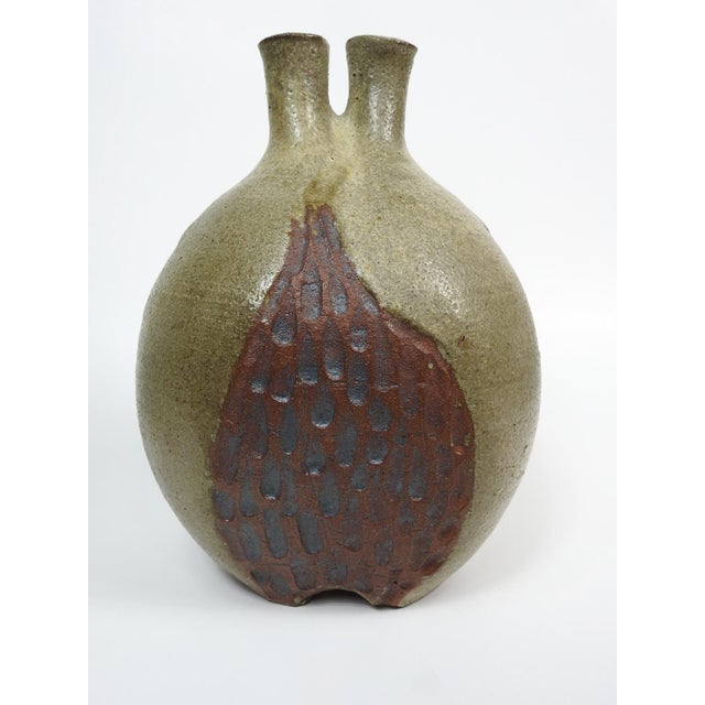 Mid 20th century olive and brown glazed pod form double neck pottery vase with textured accents. Partial mark on bottom,...