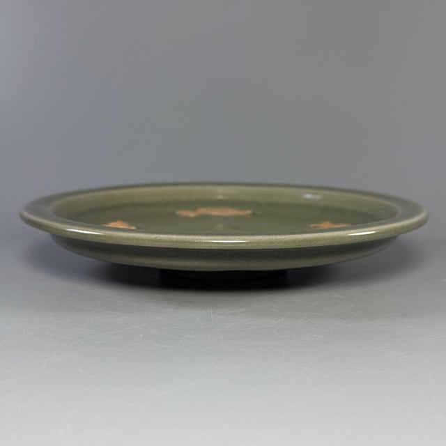 Vintage Chinese celadon plate with hand‑carved fish motif. Good condition with natural age marks. It will be carefully...