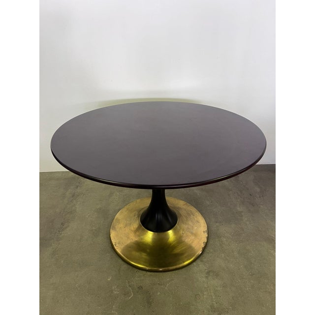 Round dining table in mahogany wood and brass base made in the 1950s.
