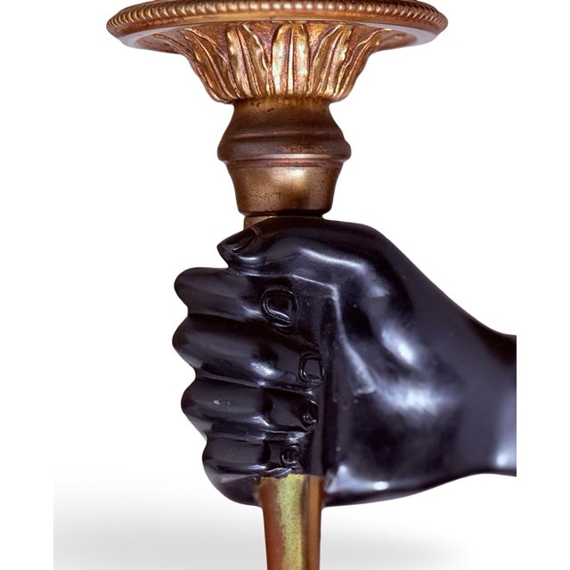 A handsome pair of bronze wall sconces, each fitted with a flame-form glass shade circa 1950. The design is in the manner...