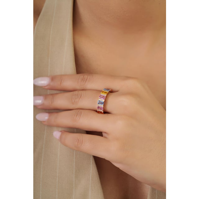 This half eternity band ring showcases a 2.03 carats of emerald-cut multicolored sapphires set in 14K yellow gold. Each...