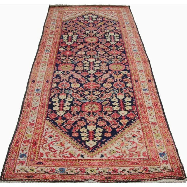 Handwoven antique Persian Hamedan runner rug featuring an all over intricate geometric motif on a navy colored field and...