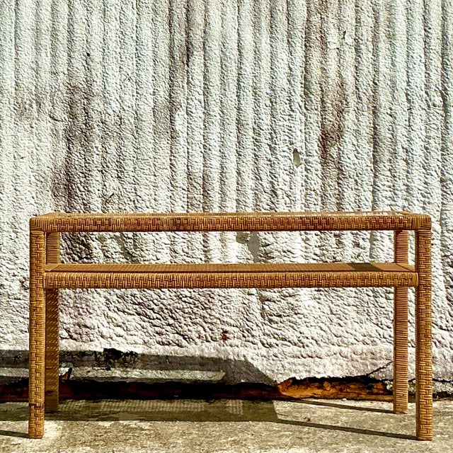 This vintage coastal console table, crafted from woven rattan, brings natural warmth and texture to any space. Its airy...