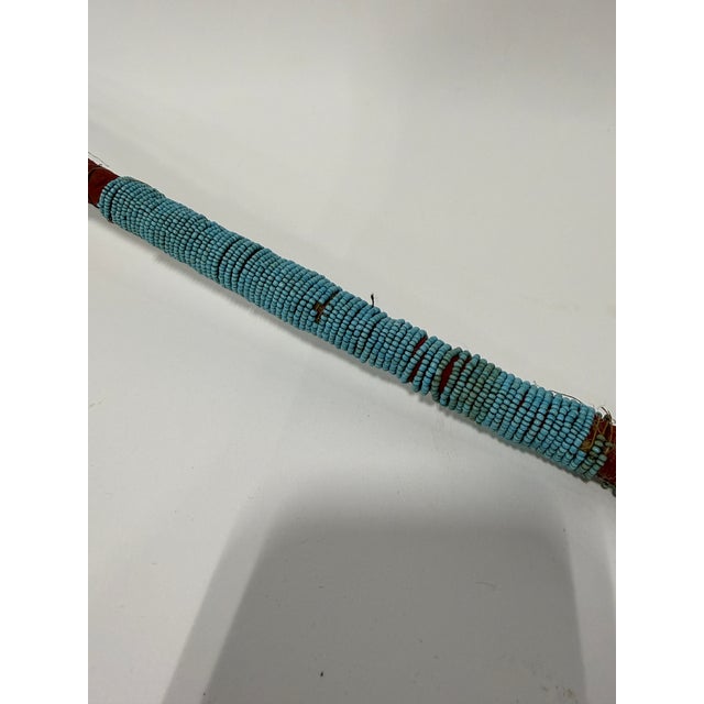 This Great Plains beaded war club is formed with a long, tapering handle terminating in a double-cone head, the entire...