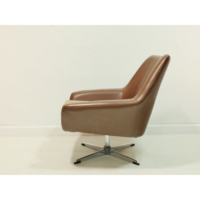 Elegant vintage swivel chair from the 1970s with a striking, organic design and exceptional seating comfort. The chair is...