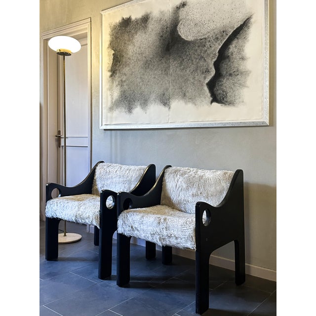 Pair of unique armchairs in black lacquered wood and faux fur with white wool, featuring curved sides and the round hole...