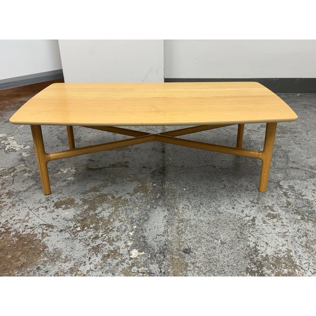 Design Plus Gallery presents the Brezza Light Oak Coffee Table from Article. The table has a rectangular oak-toned...