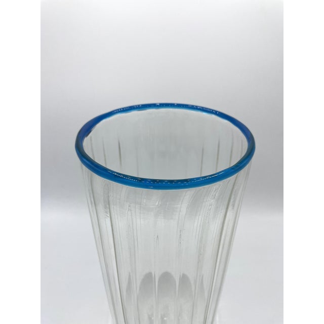 Transparent vase with a blue rim made by Venini based on a design by Thorsen & Carlsson. These two designers' distinctive...