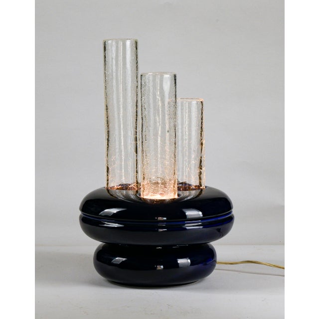 This futurist table lamp, made in Italy in 1970, is a remarkable example of vintage design. It features a blue porcelain...