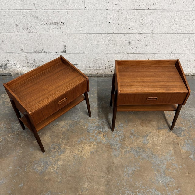 This pair of Danish teak nightstands has a clean and practical mid-century form, with single drawers, open lower shelves,...