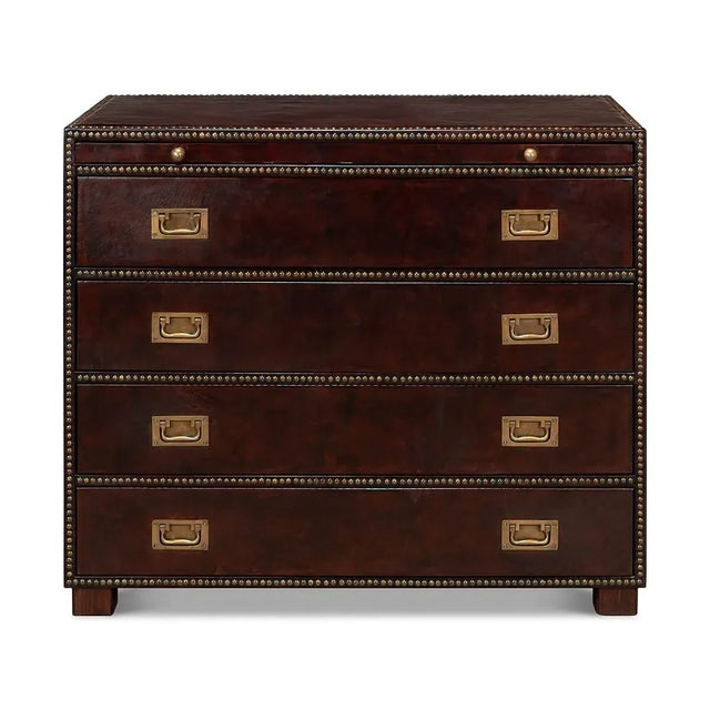 A Campaign style dresser with antique brown leather-wrapped sides. With four drawers and a slide, brass handles, and...