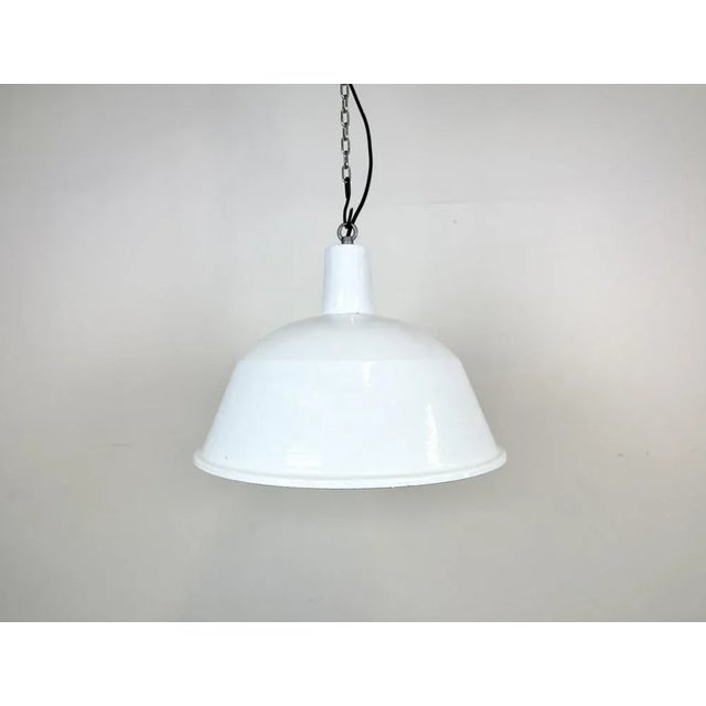 This industrial lamp was made by EMAX in Hungary during the 1960s. It features a white enamel shade with white enamel...
