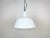 This industrial lamp was made by EMAX in Hungary during the 1960s. It features a white enamel shade with white enamel...