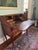 Charming antique slant-front secretary desk featuring solid wood construction, cabriole legs, and a warm reddish-brown...