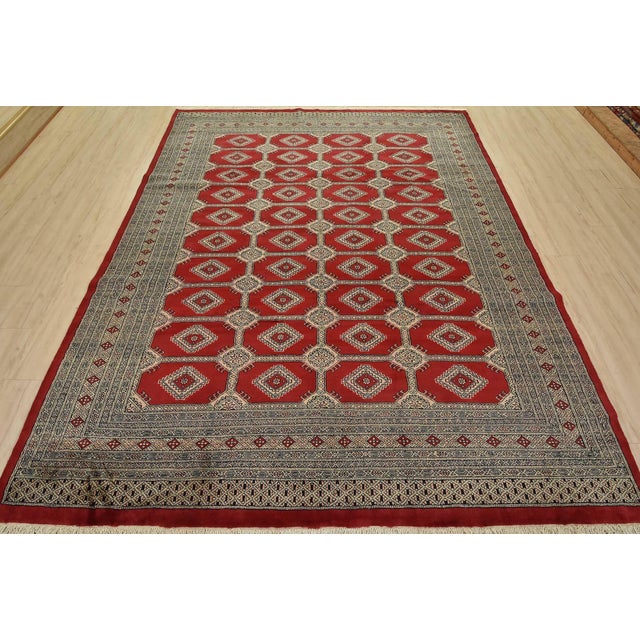 A tribal Bokhara Jaldar rug hand-knotted with fine wool on a cotton foundation. This rug features rows of repeating...