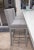 Two gray bar stools with sumptuous grey fabric seats and unique painted wood.There are no identifying manufacturers on the...