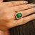 This luxurious Princess Diana inspired ring showcases a stunning emerald-cut emerald weighing 7.22 carats, artfully set in...