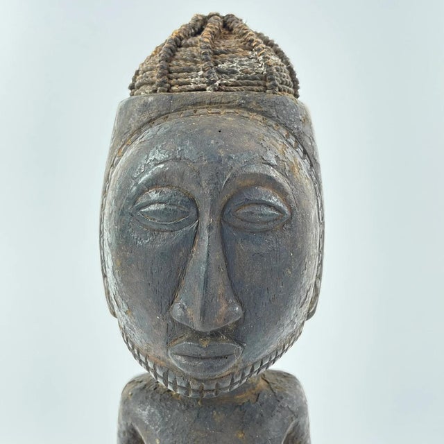 Hand-carved wood Kusu male figure with distinct body markings and influence from their Songye and Hemba neighbors. This...