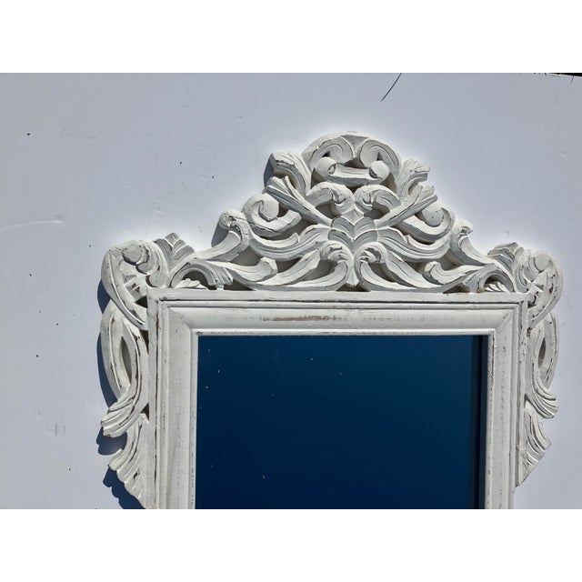 This carved wood mirror is painted The style is influenced by early European carvings Nice solid piece