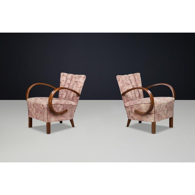 Sculptural Art Deco armchairs by Jindřich Halabala, featuring iconic Czech bentwood armrests and original upholstery—an...