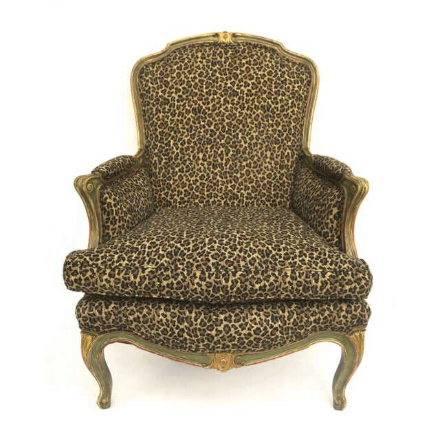 French Louis XV Style gilt and painted bergere chair with a leopard print upholstery. Loose cushion. The term "bergere"...
