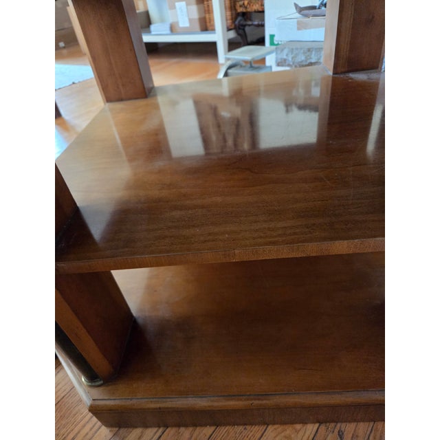 Very nice heavy solid side table manufactured by Baker. Square shape with angled corners. Two shelves beneath table top.